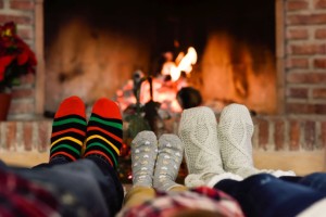 Feet in Christmas socks near fireplace. Family relaxing at home.